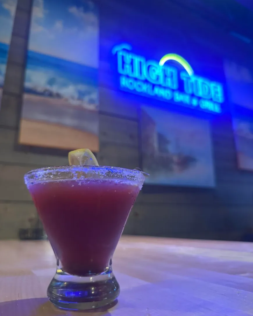 Margarita on the bar under the High Tide neon sign